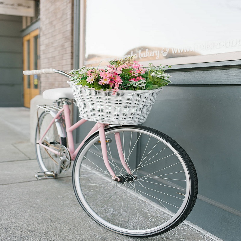 Decorative bicycle with a basket of flowers near the city cafe