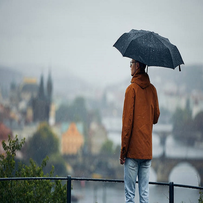 Man with umbrella during rain in city